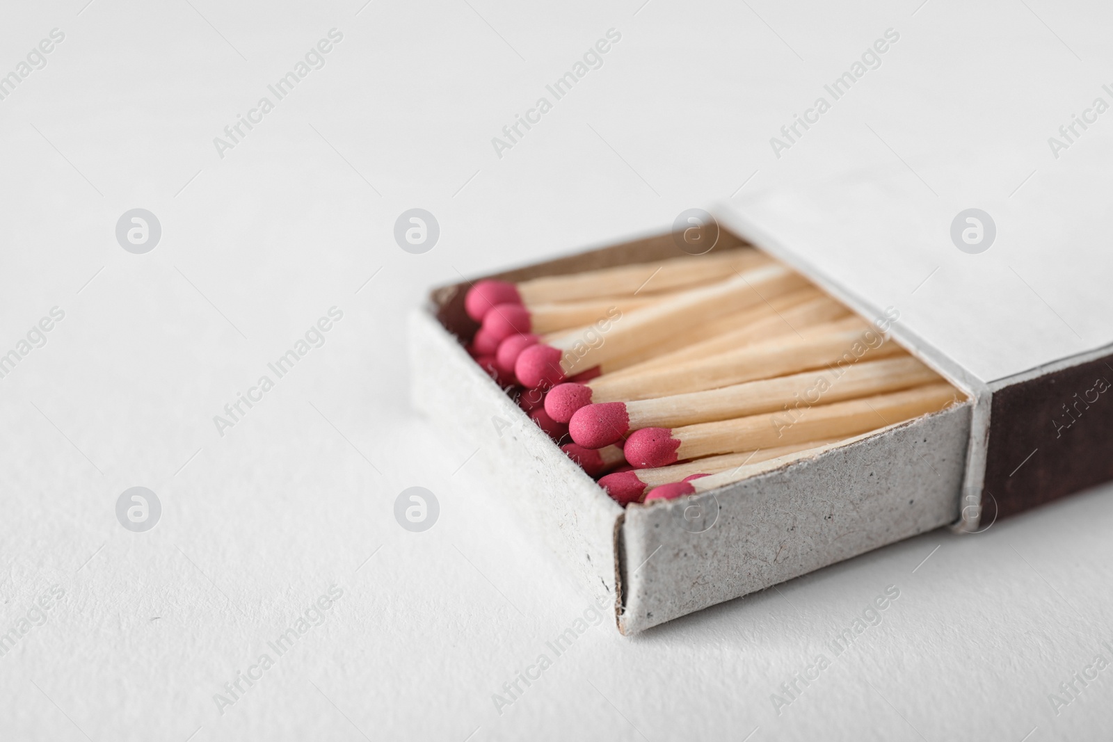 Photo of Cardboard box with matches on light background