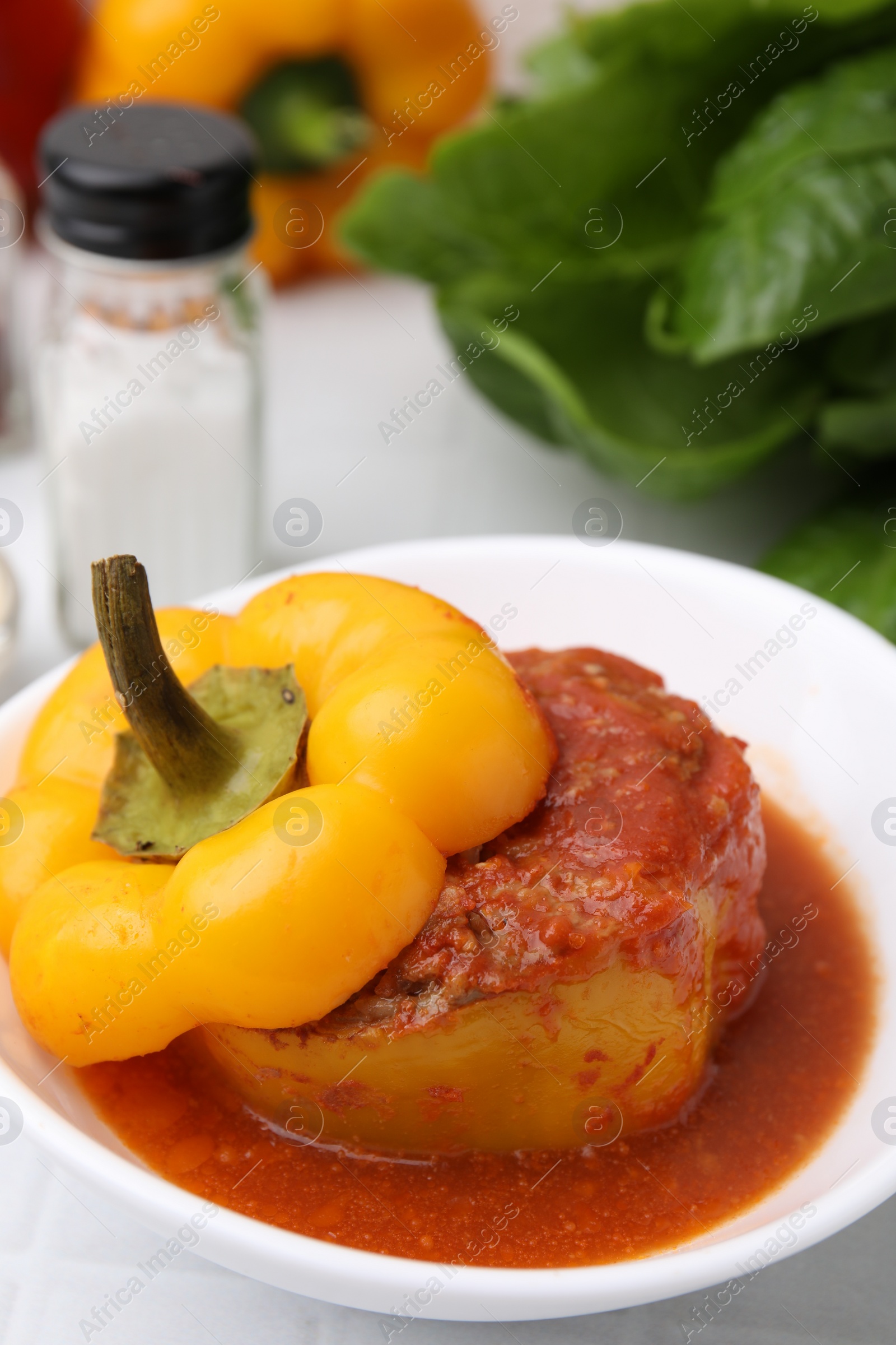 Photo of Delicious stuffed bell pepper on white tiled table, closeup