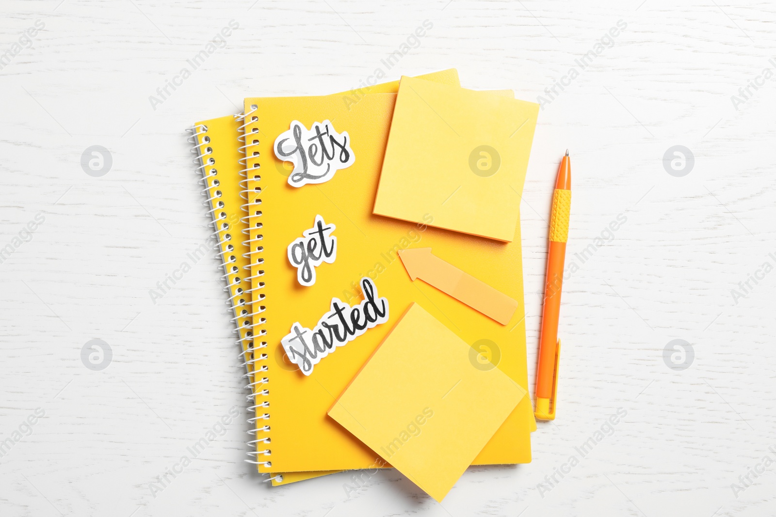 Photo of Sheets of paper with phrase Let's Get Started and stationery on white table, flat lay