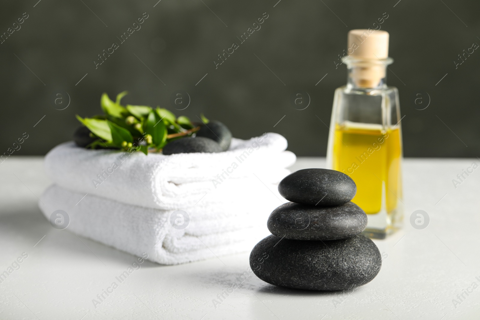 Photo of Spa stones, towels and oil on white table