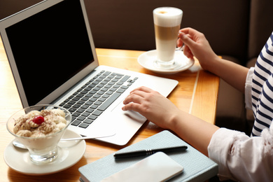 Photo of Blogger working with laptop in cafe, closeup