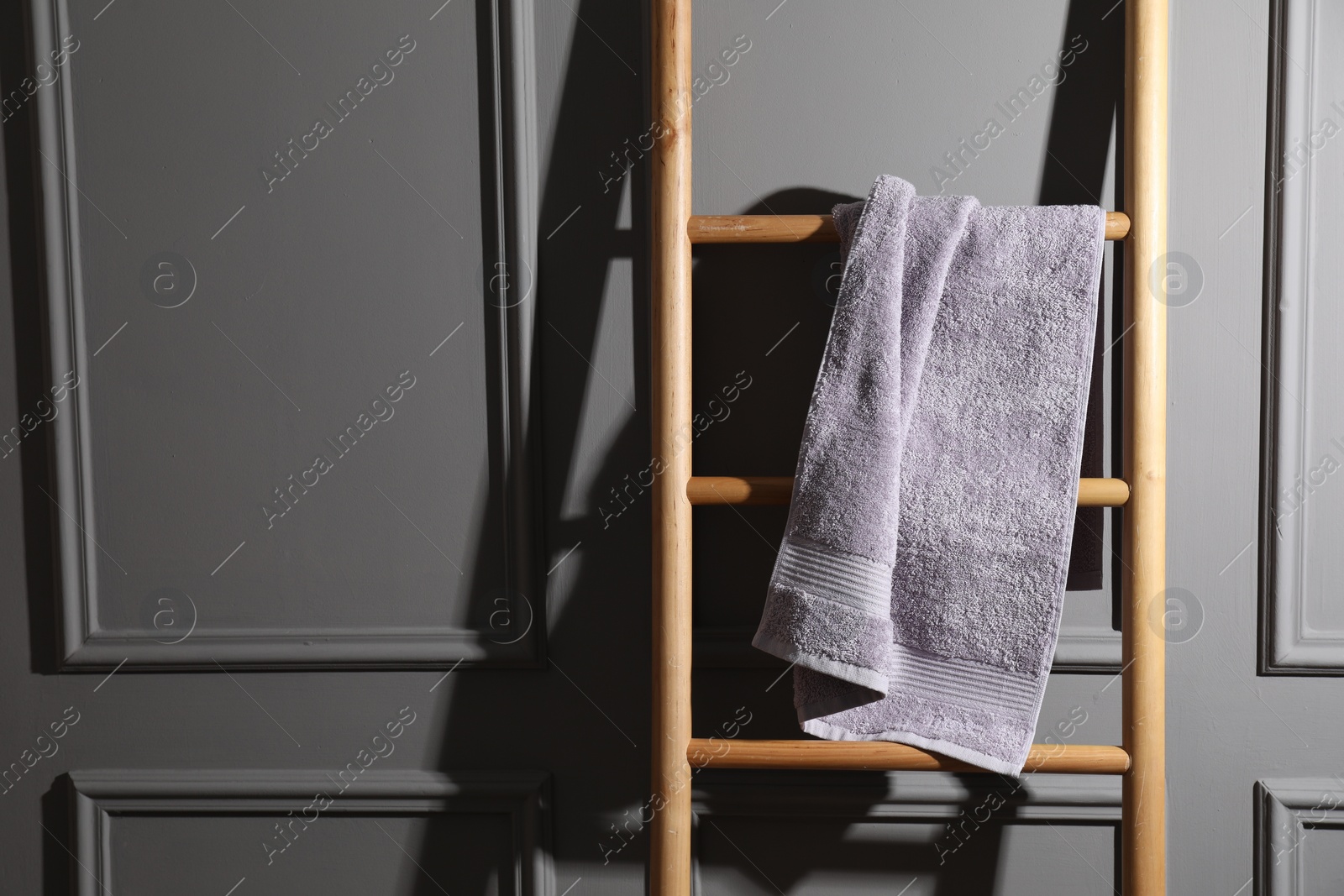 Photo of Terry towel on wooden ladder indoors, space for text