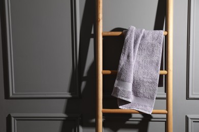 Photo of Terry towel on wooden ladder indoors, space for text