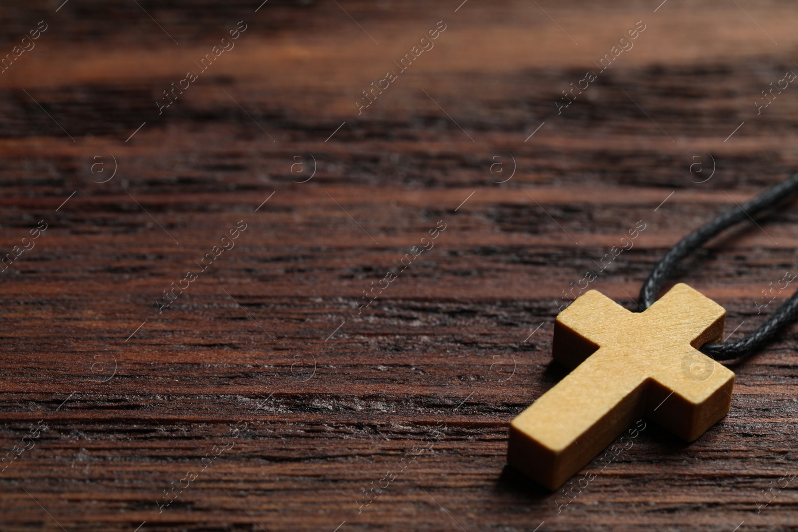 Photo of Wooden Christian cross on table, closeup. Space for text