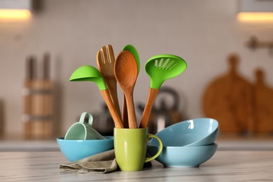 Photo of Set of different cooking utensils and ceramic dishes on white table in kitchen