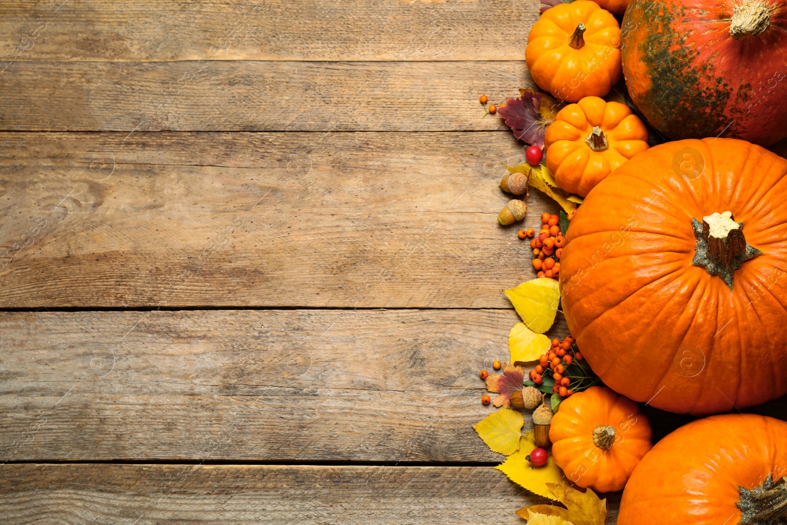 Photo of Flat lay composition with pumpkins and autumn leaves on wooden table. Space for text