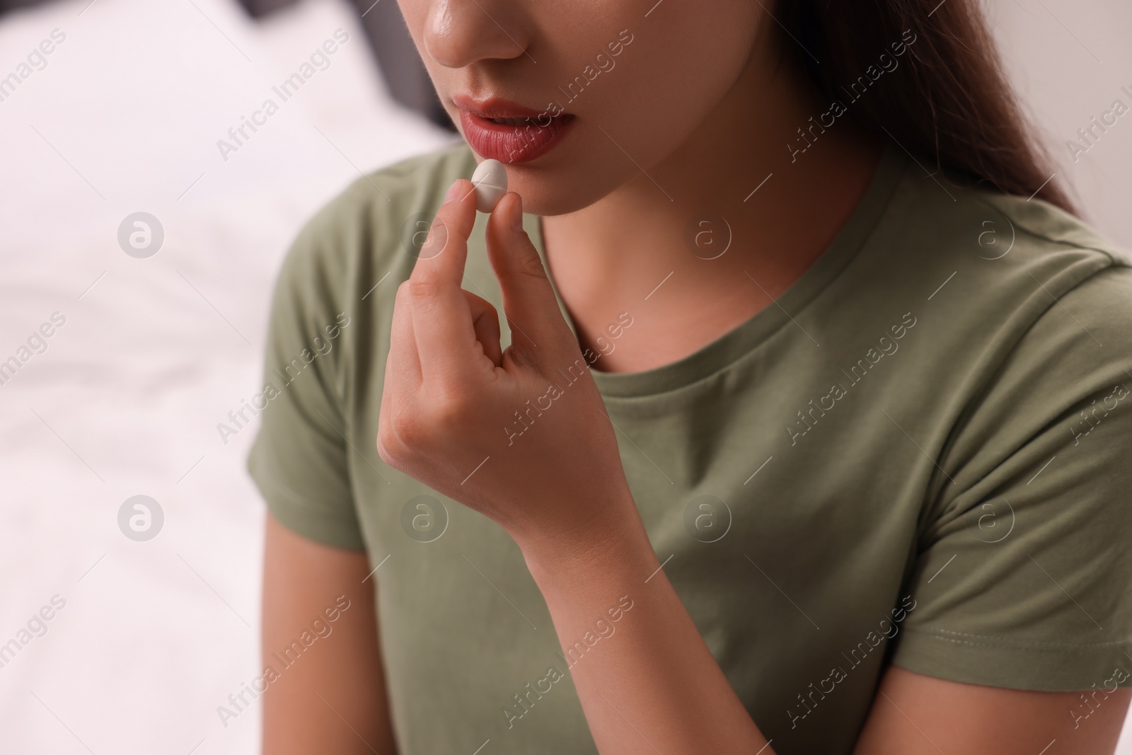 Photo of Woman taking antidepressant pill on blurred background, closeup