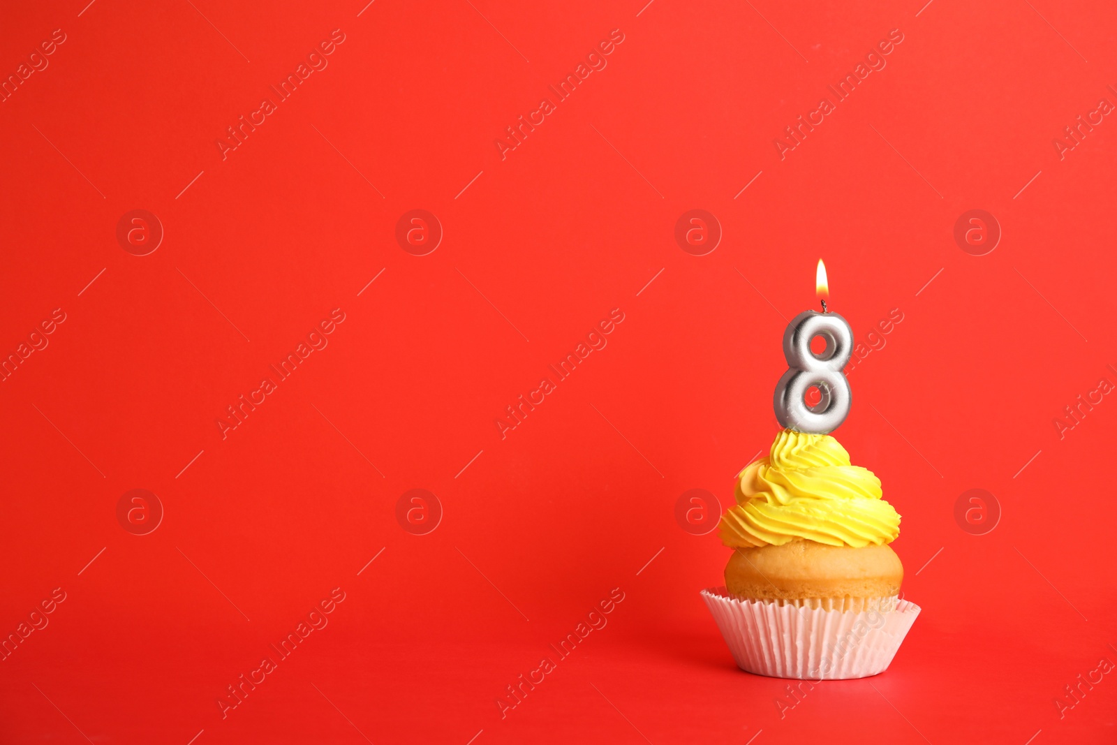 Photo of Birthday cupcake with number eight candle on red background, space for text