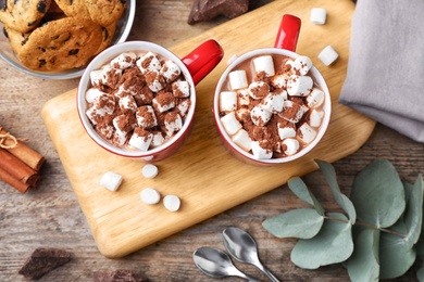 Photo of Flat lay composition of tasty cocoa with marshmallows on wooden table