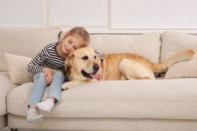 Photo of Young girl with her adorable dog on couch at home