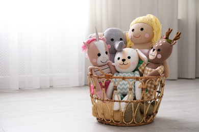 Funny stuffed toys in basket on floor, space for text. Children's room interior decor