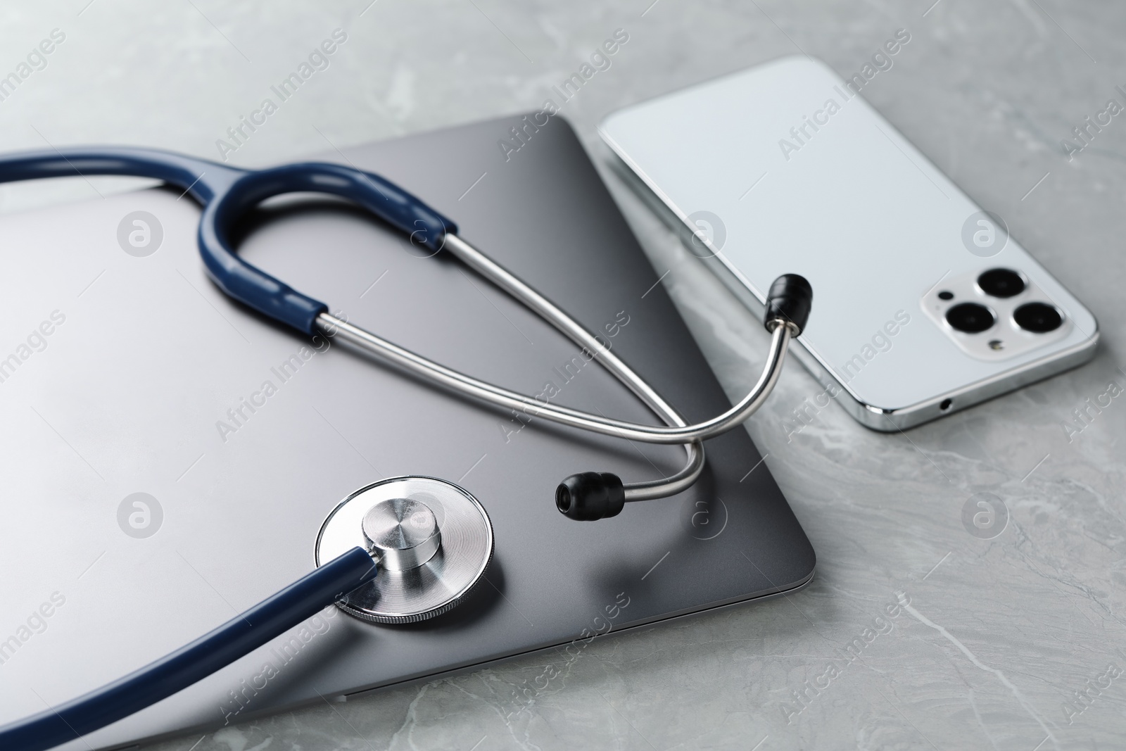 Photo of Modern electronic devices and stethoscope on grey table