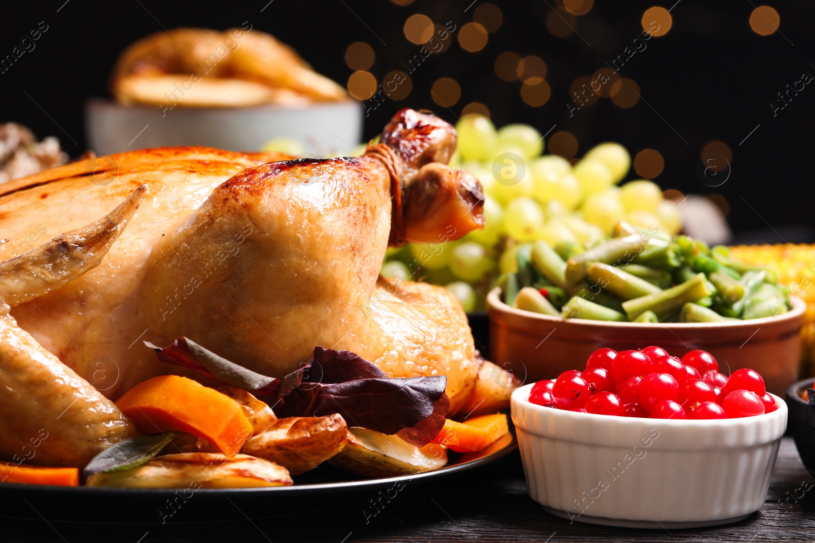 Photo of Traditional Thanksgiving day feast with delicious cooked turkey and other seasonal dishes served on table, closeup