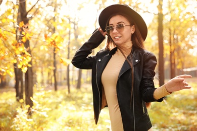 Photo of Beautiful happy woman walking in park on autumn day