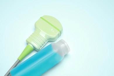 Ultrasonic transducer and ultrasound transmission gel on light background, closeup. Space for text