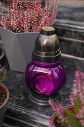 Photo of Grave lantern on grey granite surface at cemetery