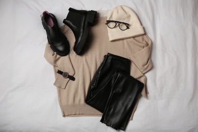 Stylish look with cashmere sweater, flat lay. Women's clothes and accessories on fabric