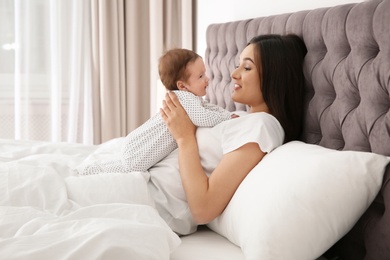 Photo of Happy woman with her cute baby on bed