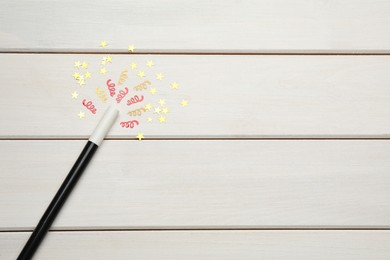 Photo of Beautiful black magic wand and confetti on white wooden table, flat lay. Space for text