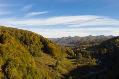 Image of Aerial view of beautiful mountain forest with road on autumn day