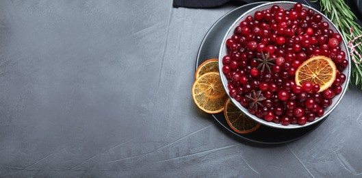 Flat lay composition with fresh ripe cranberries on grey table, space for text. Banner design