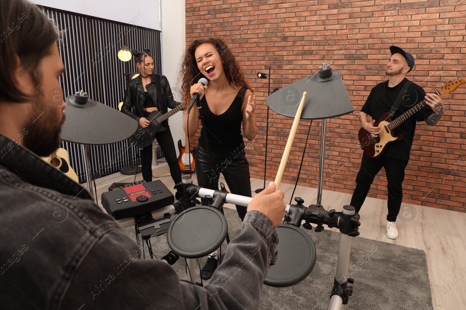 Photo of Music band performing in modern recording studio