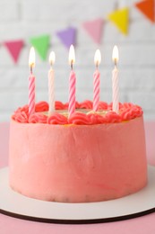Photo of Cute bento cake with tasty cream and burning candles on pink table
