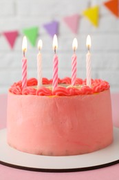 Cute bento cake with tasty cream and burning candles on pink table