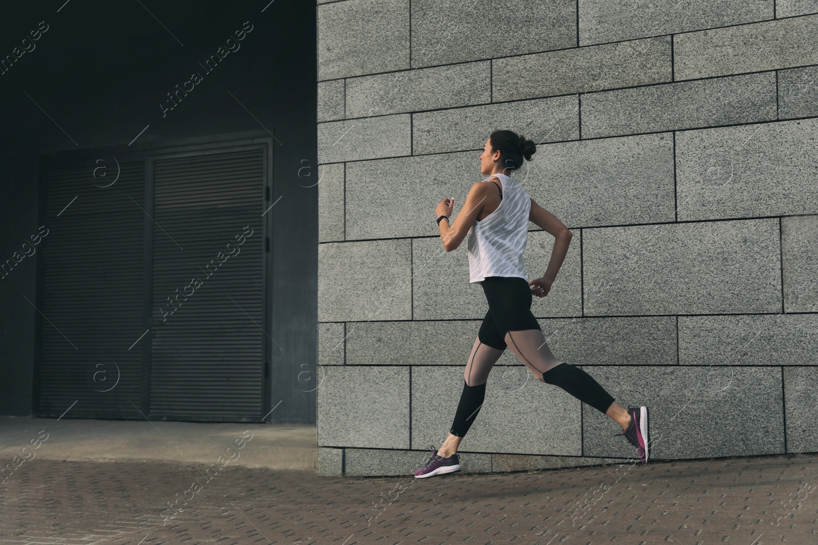 Photo of Beautiful sporty young woman running on street