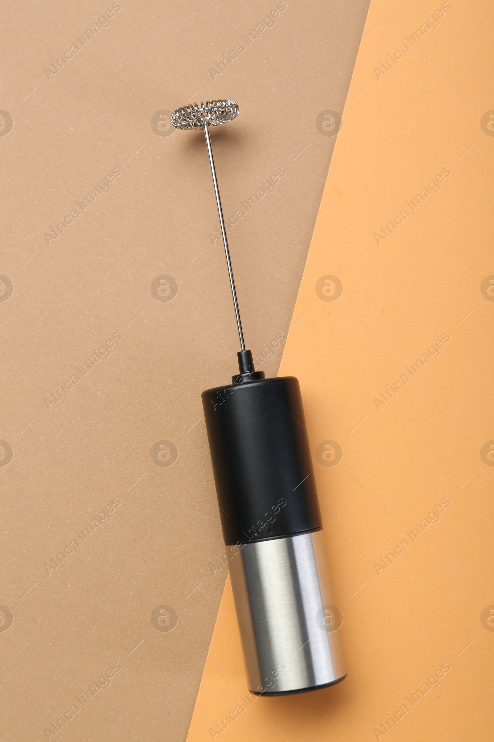 Photo of Milk frother wand on color background, top view