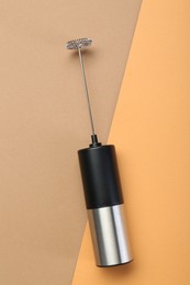 Milk frother wand on color background, top view