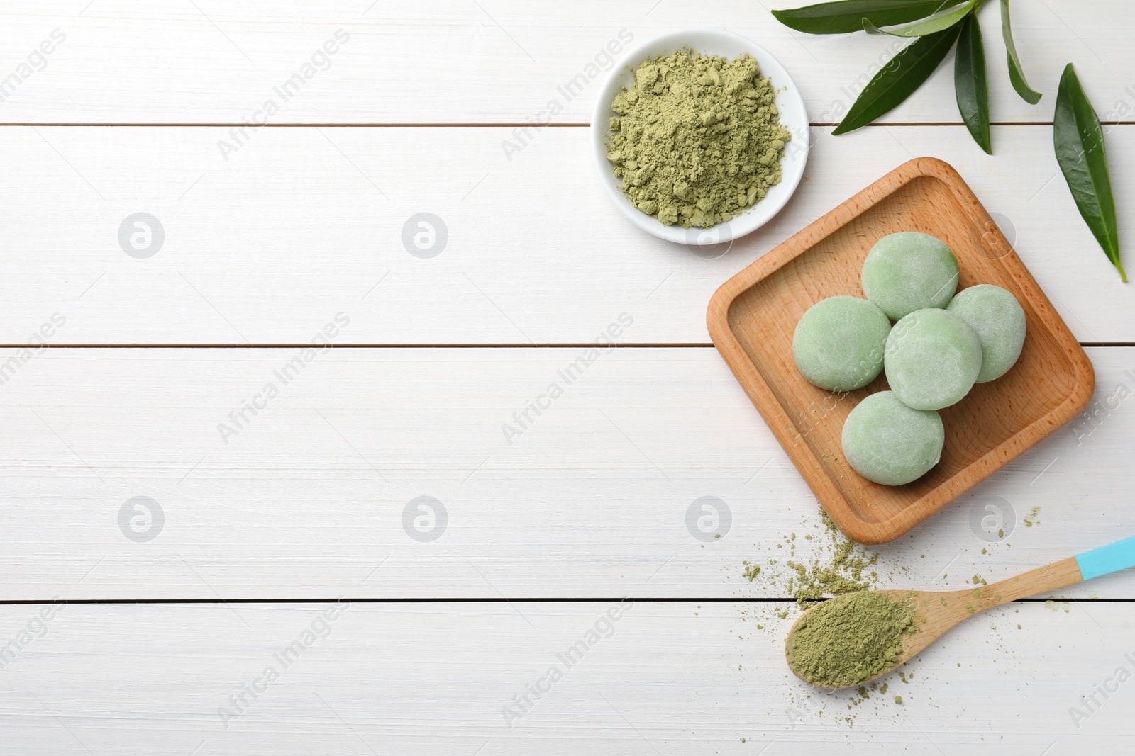 Photo of Delicious matcha mochi on white wooden table, flat lay. Space for text