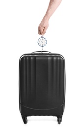 Man weighing stylish suitcase on white background