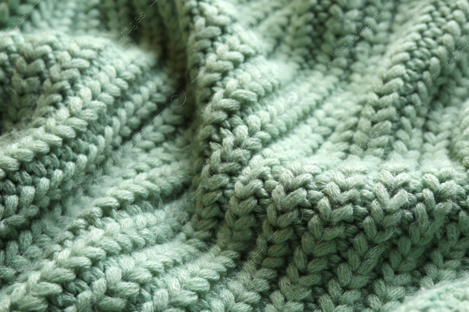 Photo of Beautiful pale green knitted fabric as background, closeup