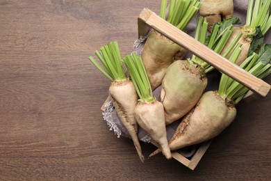 Photo of Basket with fresh sugar beets on wooden table, top view. Space for text