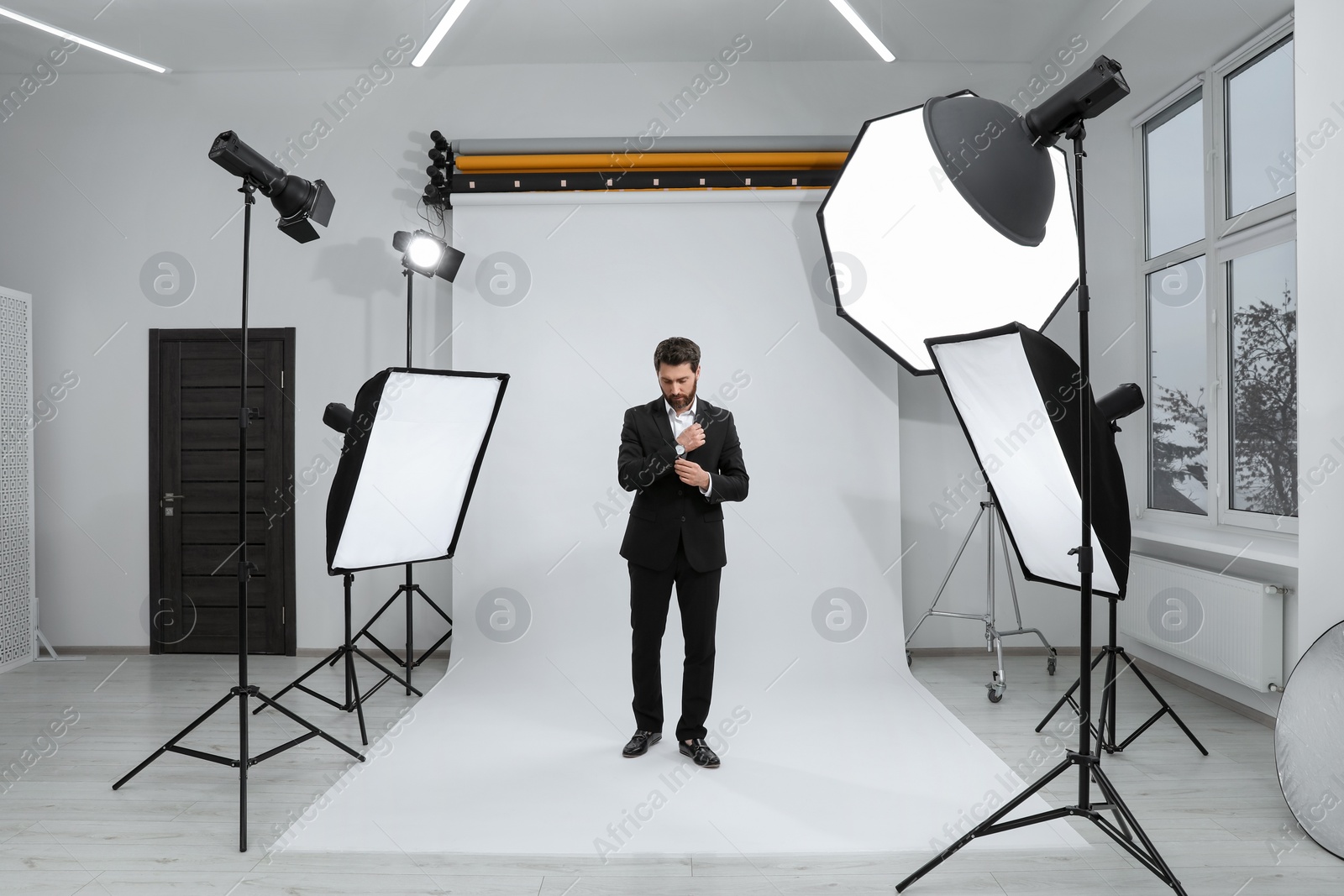 Photo of Handsome model posing in modern studio. Professional photo session