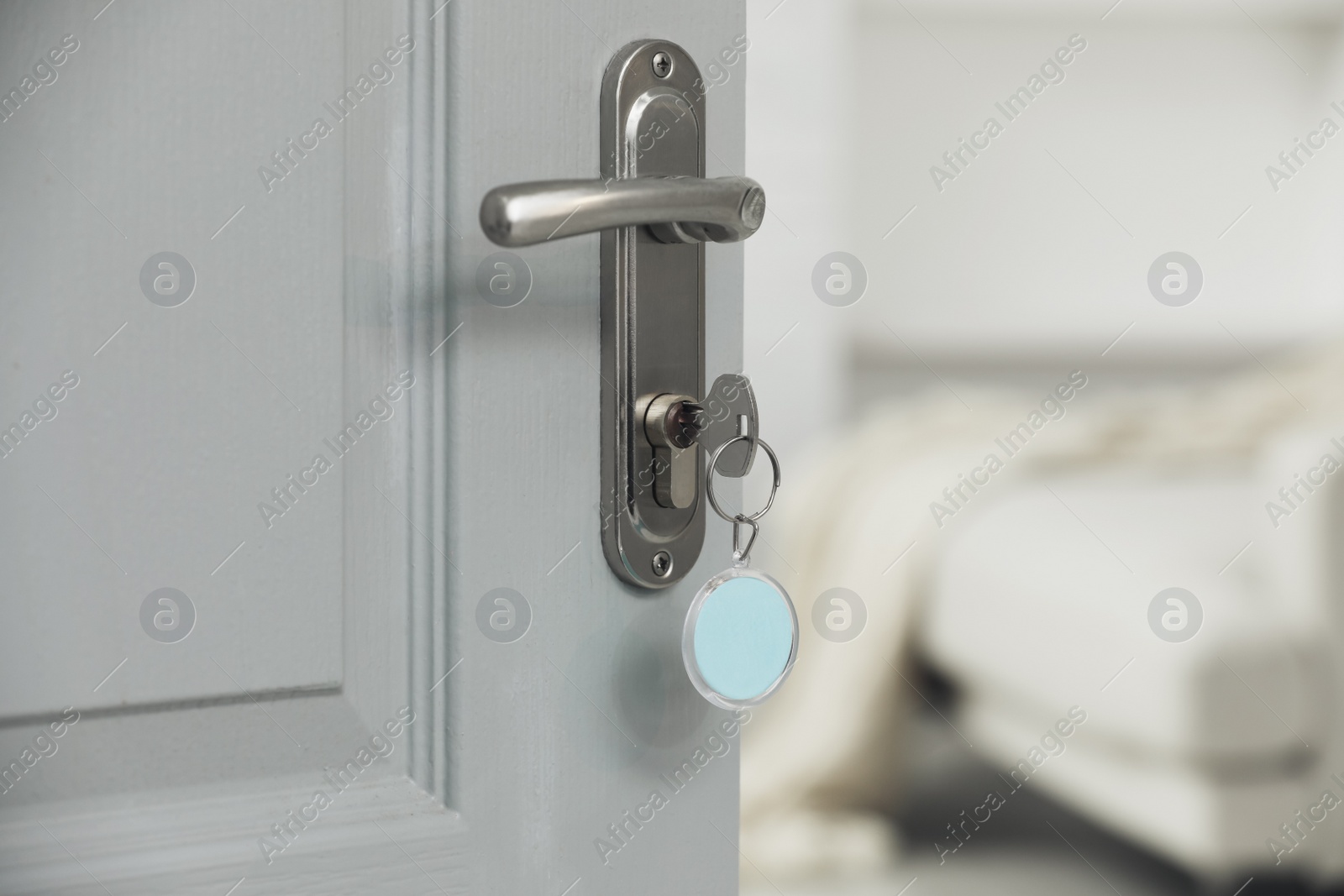 Photo of Closeup view of door with key open into room. Space for text