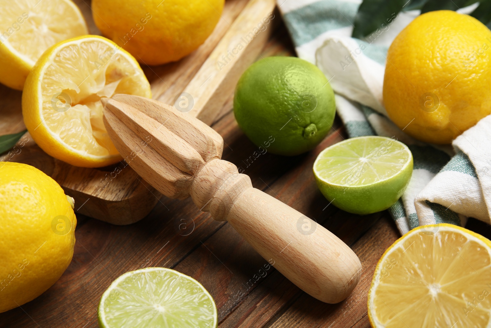 Photo of Squeezer with lemons on wooden table, closeup