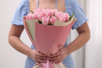 Photo of Woman with bouquet of beautiful fresh tulips on blurred background, closeup