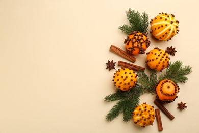 Flat lay composition with pomander balls made of fresh tangerines and orange on beige background. Space for text