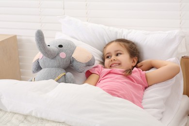 Photo of Happy little girl awaking in cosy bed