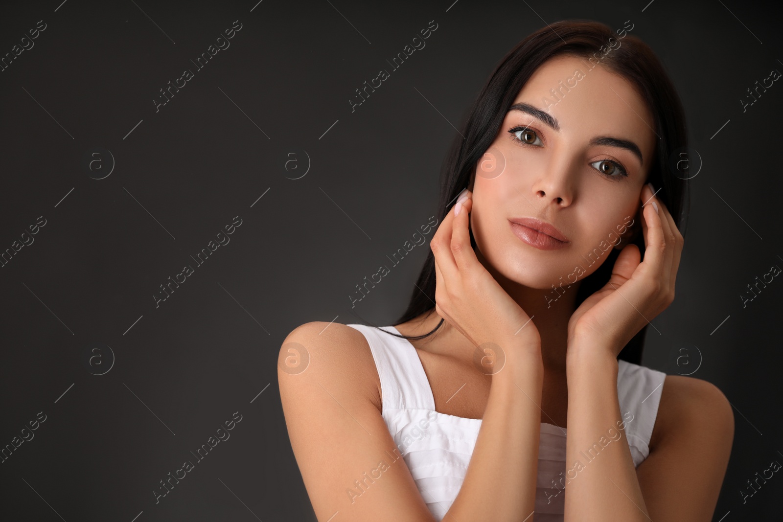 Photo of Portrait of beautiful young woman on dark grey background