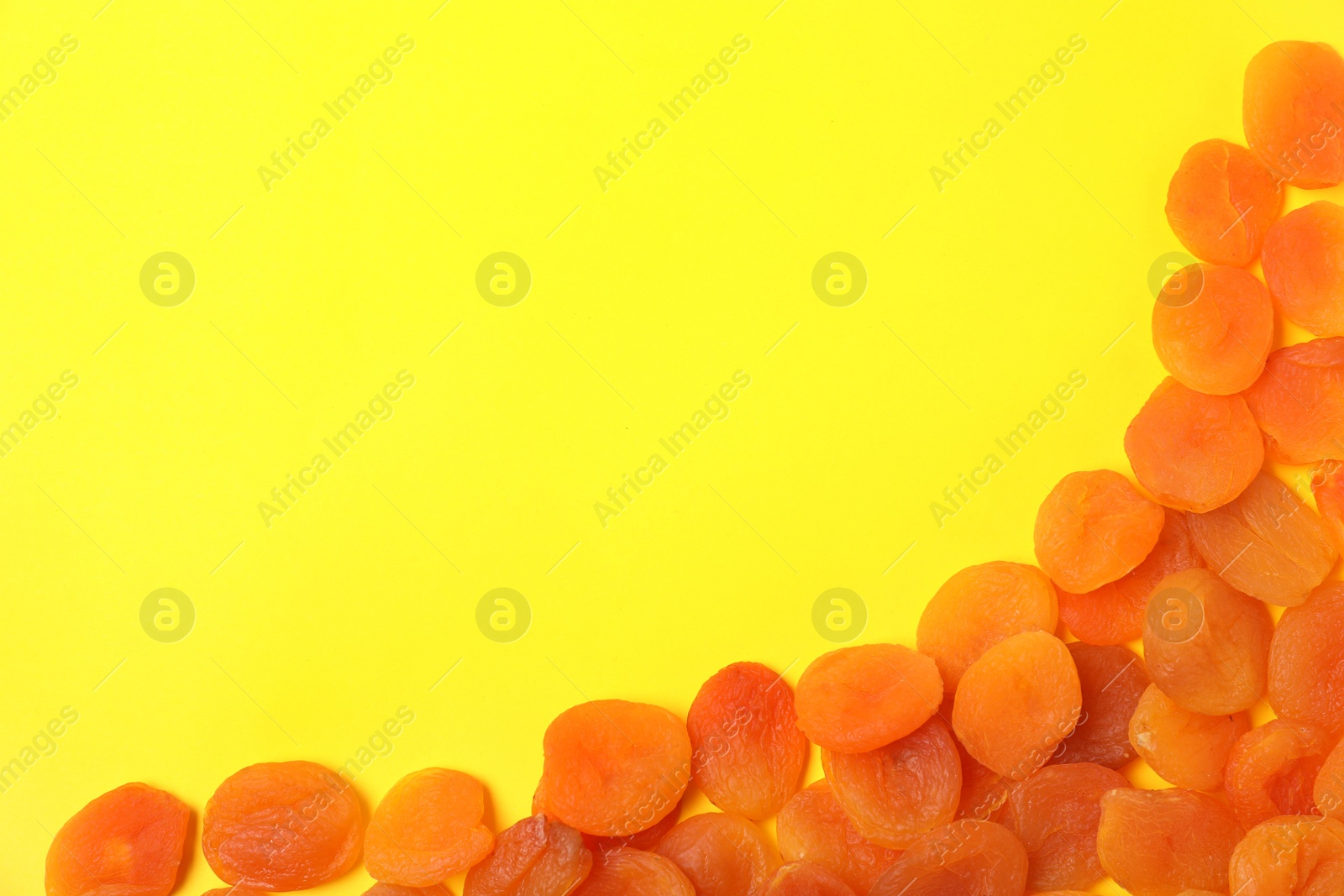 Photo of Dried apricots on color background, top view with space for text. Healthy fruit