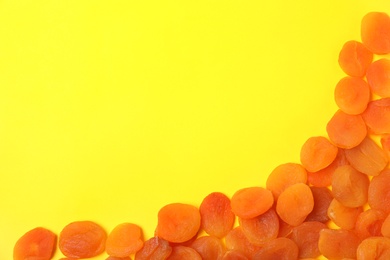 Photo of Dried apricots on color background, top view with space for text. Healthy fruit
