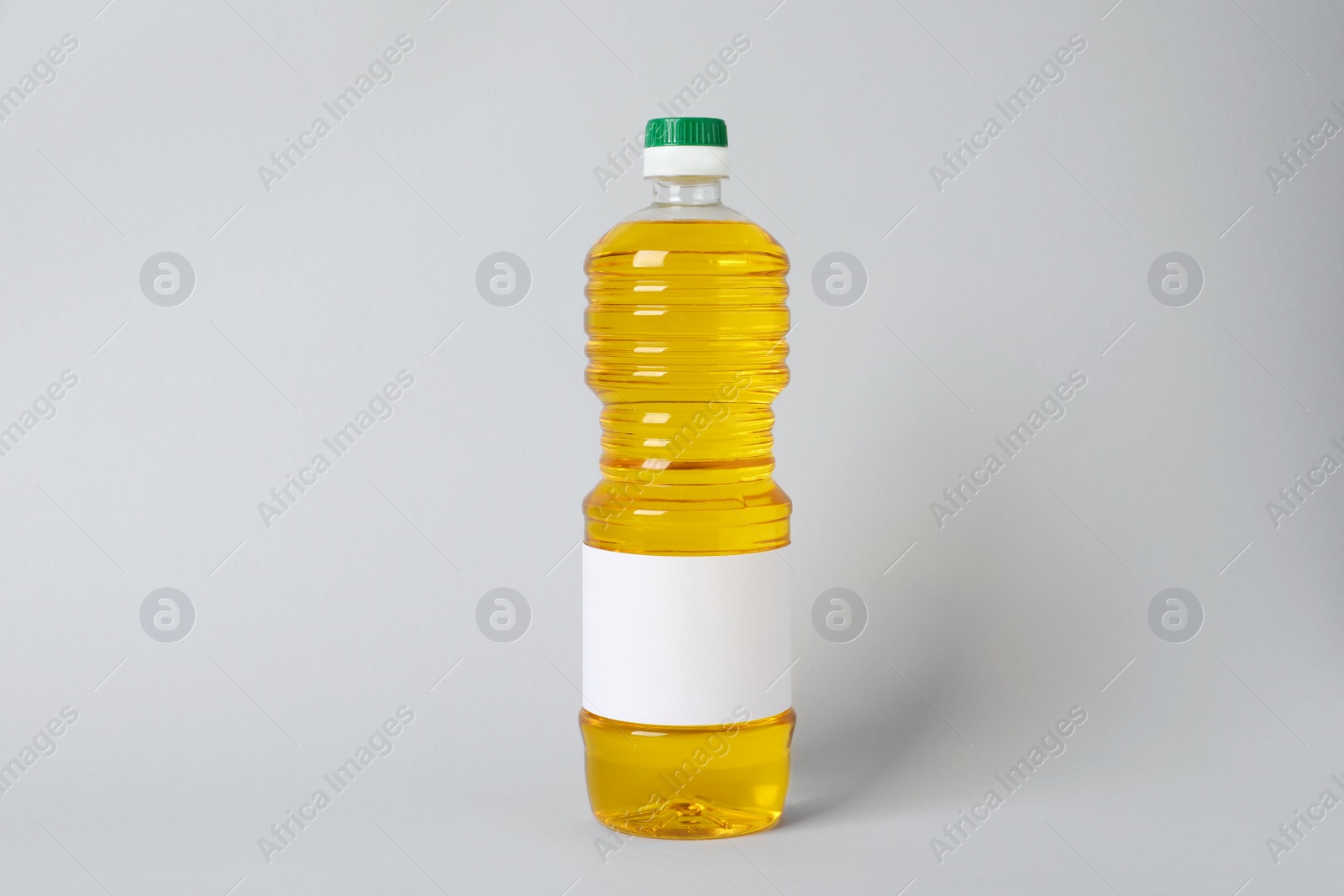 Photo of Bottle of cooking oil on light grey background