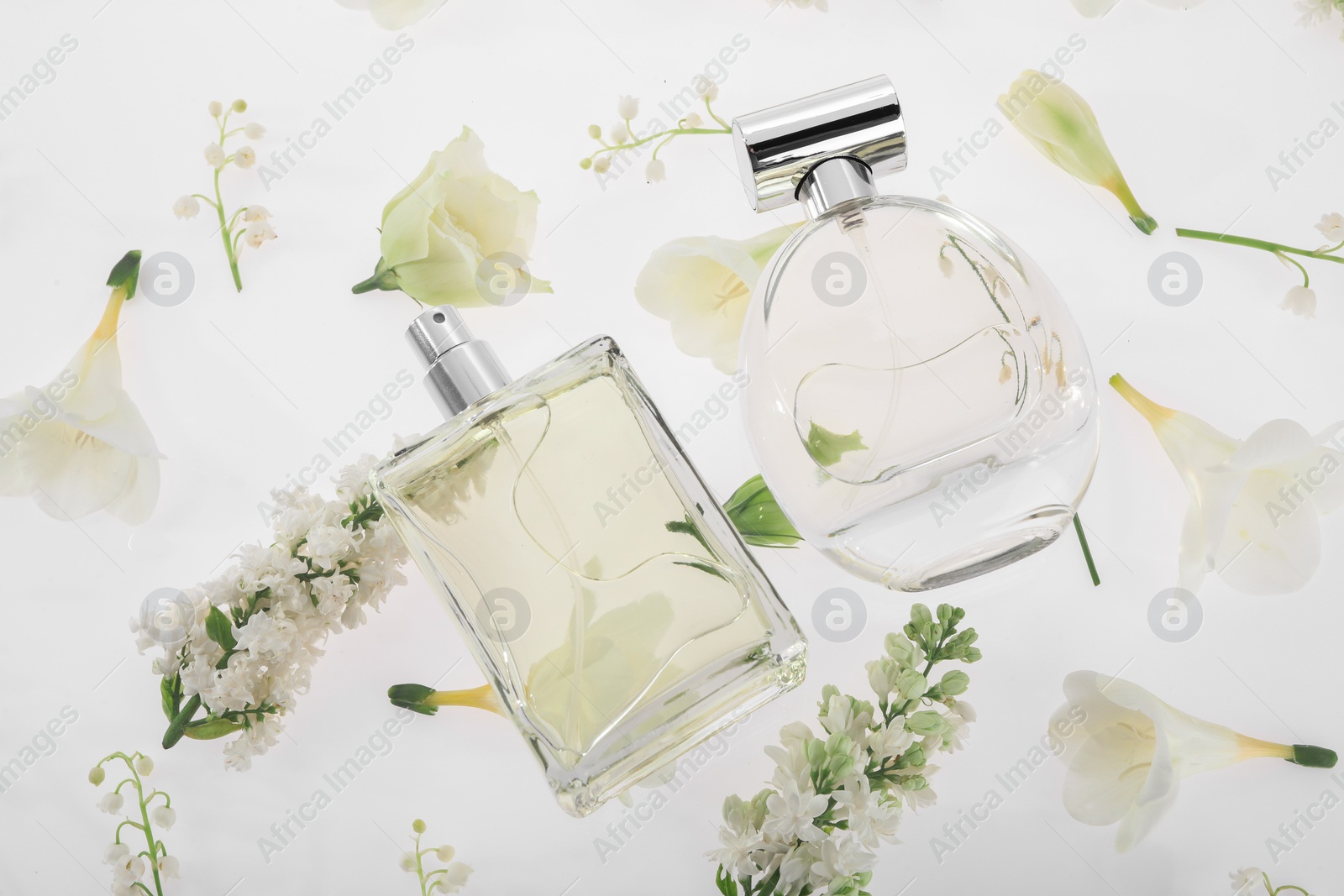 Photo of Luxury perfumes on spring floral decor, above view