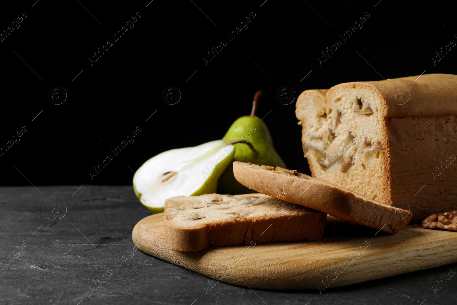 Photo of Tasty cut pear bread on black table. Homemade cake