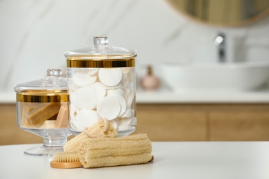 Composition of glass jar with cotton pads on table in bathroom. Space for text