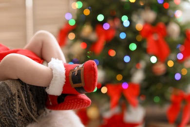 Cute baby in Christmas costume at home, focus on legs