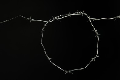 Photo of Shiny metal barbed wire on black background